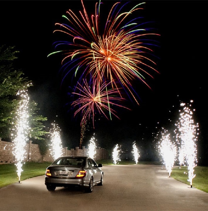 A bride and groom standing in front of fireworks
